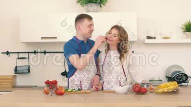 一对美丽而热情的夫妇在厨房里互相喂草莓。